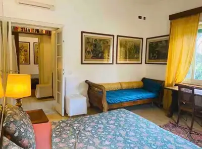 a living room with a blue couch and a bed at Rome Museum House in Rome