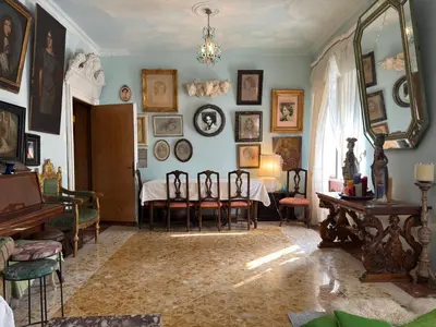 a living room with chairs and a table and a mirror at Rome Museum House in Rome