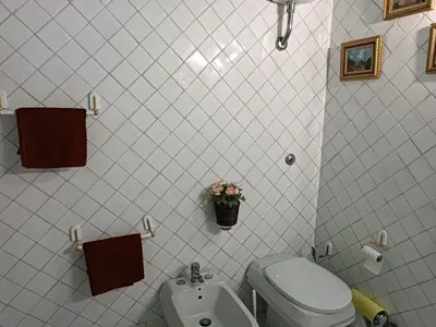a white bathroom with a sink and a toilet at Coronari 45 apartment in Rome