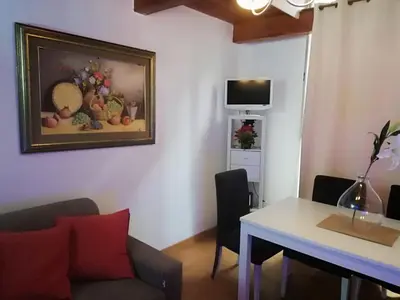 a living room with a table and a painting on the wall at Coronari 45 apartment in Rome