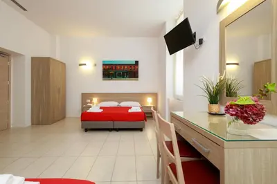 a bedroom with a red bed and a desk at San Luigi - Residenza Gemelli in Rome