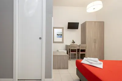 a bedroom with a red bed and a dining room at San Luigi - Residenza Gemelli in Rome