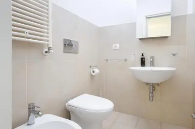 a white bathroom with a toilet and a sink at San Luigi - Residenza Gemelli in Rome
