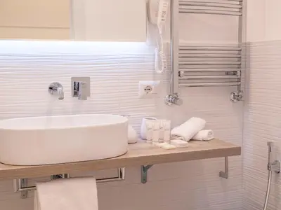 a white bathroom with a sink and a shower at Vatican Palace Suites by Premium Suites Collection in Rome
