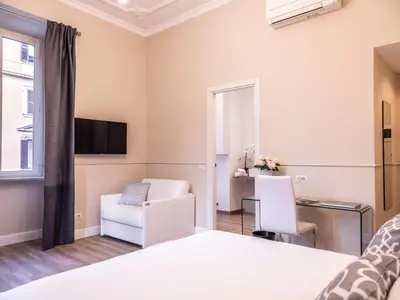 a bedroom with a bed and a chair and a desk at Vatican Palace Suites by Premium Suites Collection in Rome
