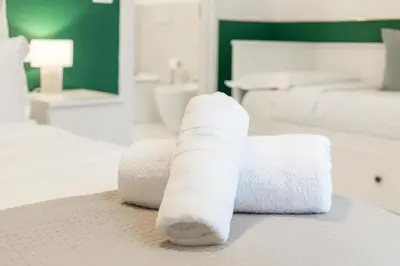 a pile of towels sitting on top of a bed at DrsRome - Roman's Ruins Colosseum in Rome