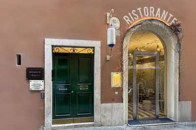 a building with a green door and a store window at Condotti Corner Apartment Piazza di Spagna in Rome