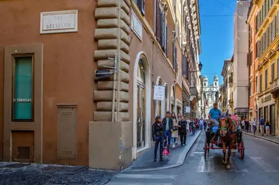 a horse drawn carriage on a city street at Condotti Corner Apartment Piazza di Spagna in Rome