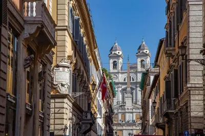 a street between buildings with a building in the background at Condotti Corner Apartment Piazza di Spagna in Rome