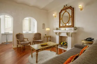 a living room with a couch and a table and a mirror at Condotti Corner Apartment Piazza di Spagna in Rome