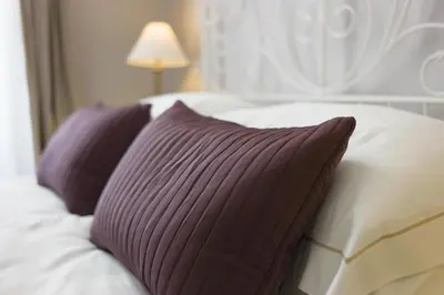 a bed with purple and white pillows on it at DD Luxury House in Rome