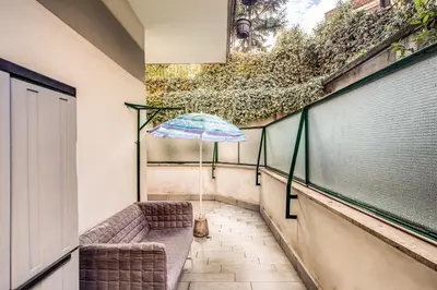 a balcony with a chair and an umbrella at M&L Apartment - Ardesia Terrace in Rome