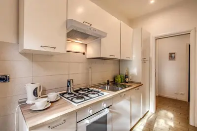 a kitchen with white cabinets and a stove top oven at M&L Apartment - Ardesia Terrace in Rome