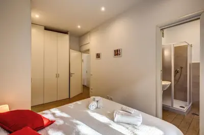a bedroom with a large white bed and a bathroom at M&L Apartment - Ardesia Terrace in Rome