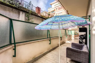 a umbrella and a chair on a balcony at M&L Apartment - Ardesia Terrace in Rome