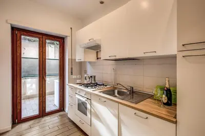 a kitchen with white cabinets and a sink at M&L Apartment - Ardesia Terrace in Rome