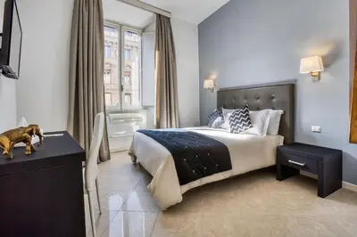 a bedroom with a large bed with a dog on a table at Ada Rooms in Rome