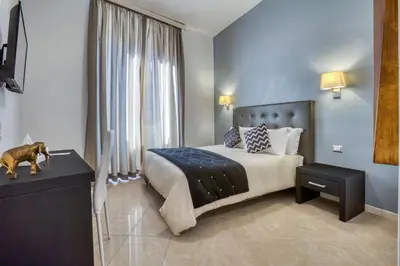 a bedroom with a bed and a dog standing on a table at Ada Rooms in Rome