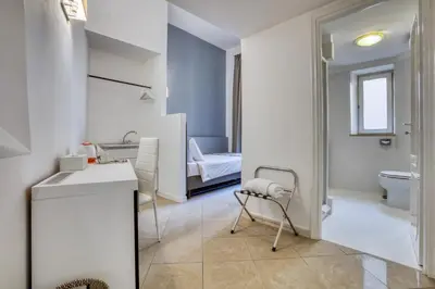 a bathroom with a sink and a toilet and a bedroom at Ada Rooms in Rome