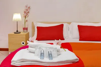 a bedroom with two beds with towels and red pillows at Affittacamere Alessia&Calliope in Rome