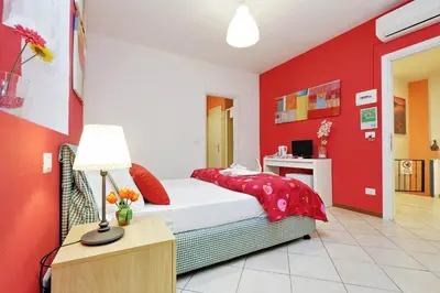 a red bedroom with a bed and a desk at Affittacamere Alessia&Calliope in Rome