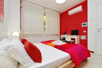 a bedroom with red walls and a bed with a desk at Affittacamere Alessia&Calliope in Rome