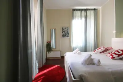 a bedroom with two beds and a red chair at Boschetto Monti Apartment in Rome