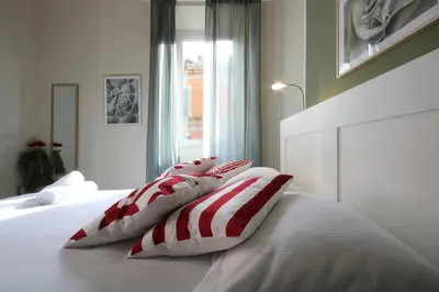 a bed with four red and white pillows on it at Boschetto Monti Apartment in Rome