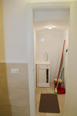 a hallway with a bathroom with a sink and a rug at DOMUS DIVI - appartamento nel cuore di Roma in Rome