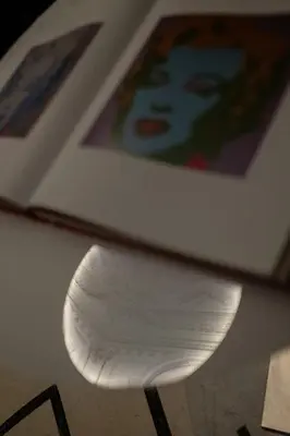 a white chair sitting next to a wall with paintings at BDB Rooms Margutta in Rome
