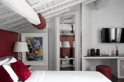a bedroom with a white bed with red pillows at BDB Rooms Margutta in Rome