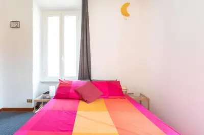 a bedroom with a colorful bed with colorful pillows at Like At Home Piramide in Rome