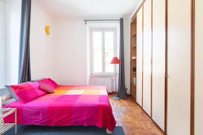 a bedroom with a pink bed and a window at Like At Home Piramide in Rome