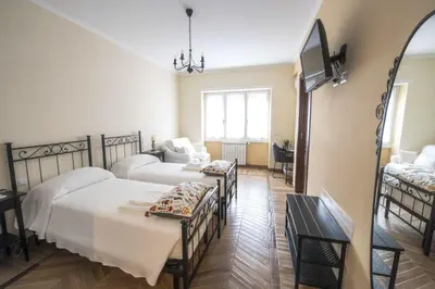 a room with two beds and a tv in it at Bed & Breakfast Vacanze Romane in Rome