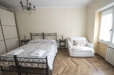 a bedroom with a bed and a chair and a window at Bed & Breakfast Vacanze Romane in Rome