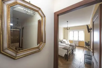 a mirror hanging on a wall next to a bedroom at Bed & Breakfast Vacanze Romane in Rome