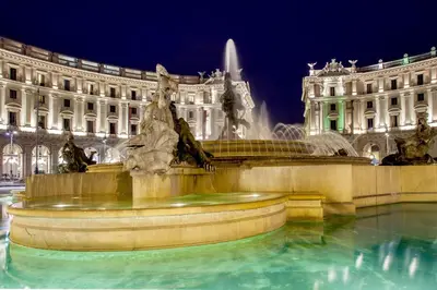 a fountain in front of a large building at night at Nazionale 51 L Rooms in Rome