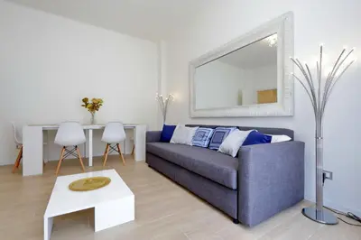 a living room with a blue couch and a mirror at My Little Holiday in Rome