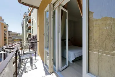 a balcony with a glass door with a bed at My Little Holiday in Rome