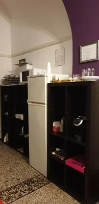 a kitchen with a white refrigerator and a purple wall at guesthouse ava roma in Rome