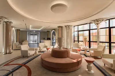 a large room with a lobby with chairs and a table at Room Mate Collection Filippo, Rome-Fontana di Trevi in Rome