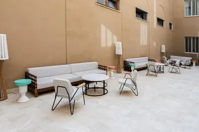 a living room with a couch and tables and chairs at Room Mate Collection Filippo, Rome-Fontana di Trevi in Rome