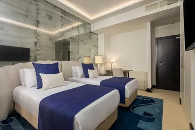 a hotel room with two beds and a tv at Room Mate Collection Filippo, Rome-Fontana di Trevi in Rome