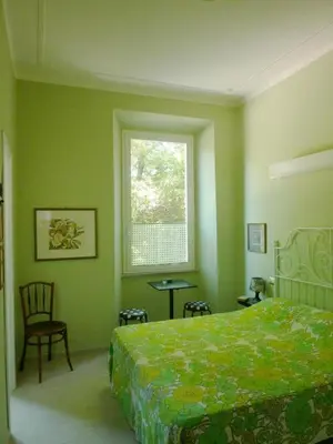 a bedroom with a bed and a window and a chair at Casa Particular 25Rooms in Rome