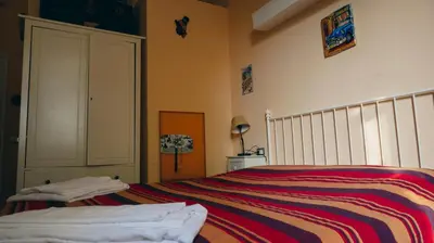 a bedroom with a bed with a striped blanket at Casa Particular 25Rooms in Rome