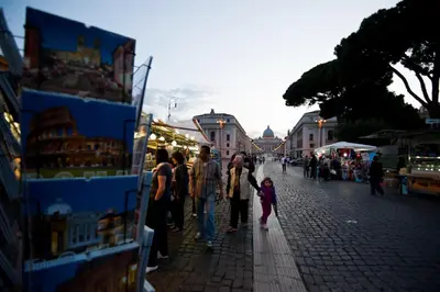 a group of people walking down a street at a market at Rome Services Porta Castello in Rome