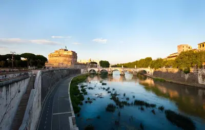 a bridge over a river in a city at Rome Services Porta Castello in Rome