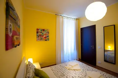 a bedroom with a bed and a yellow wall at Rome Services Porta Castello in Rome