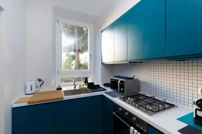 a kitchen with blue cabinets and a sink and a window at Donatello Loft in Rome