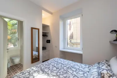 a bedroom with a bed and two windows at Donatello Loft in Rome